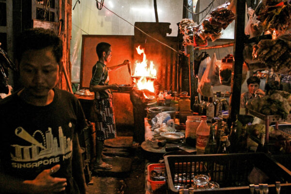 San Pyout, 56, cooks dishes as he receives an order from a customer.