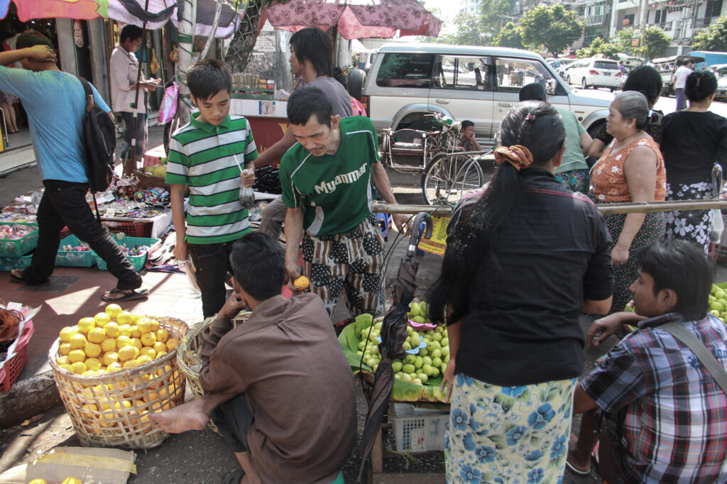 San Pyout and his eldest son buy fruit in the morning. San Pyout’s two sons do not live with him; they live with their uncle in the same neighborhood.
