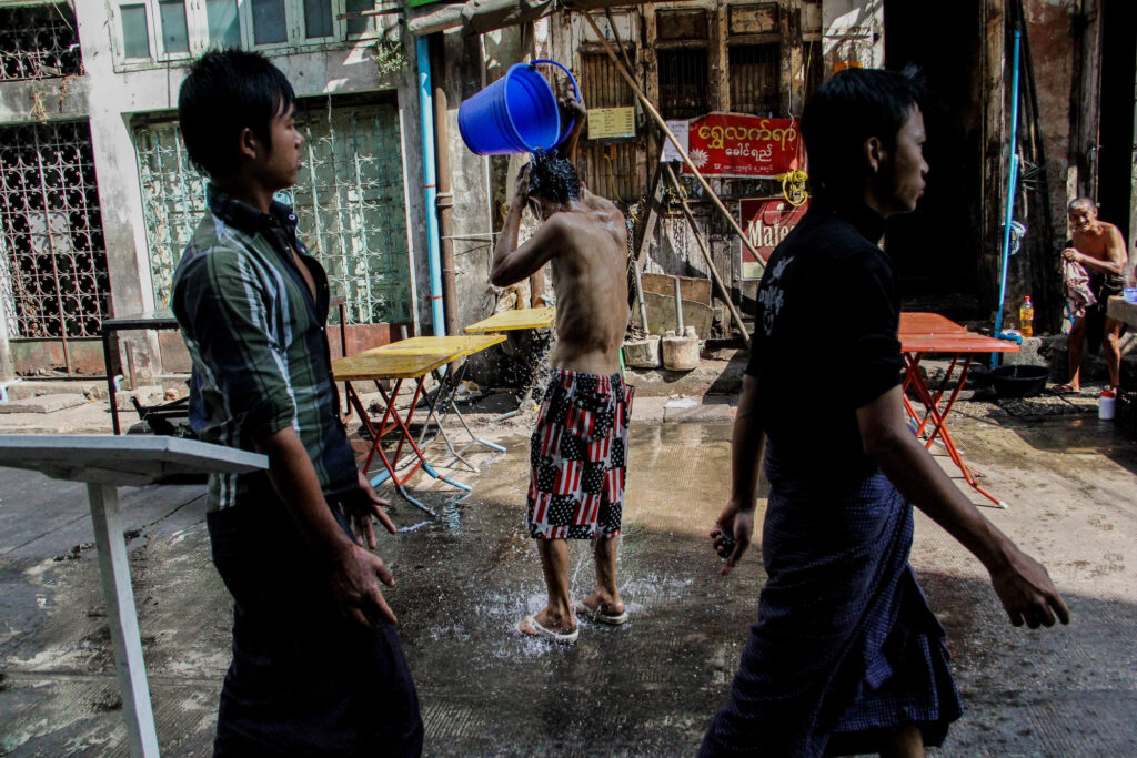 Taking a shower in the middle of the street is his favorite way to clean himself, while also washing the pavement where he will set up his tables later in the evening.