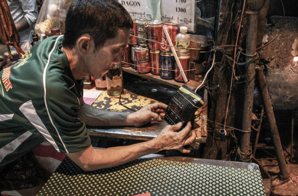 Playing an old radio is the only entertainment he can provide for his customers.