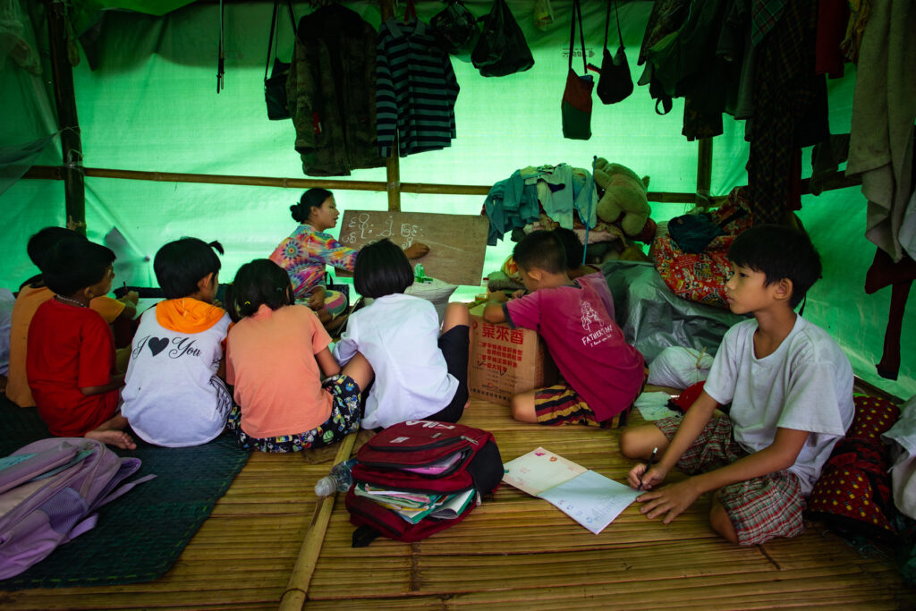 Children learn at a makeshift school inside an IDP camp located in a Kachin Independent Army-controlled area, 5 August 2024.