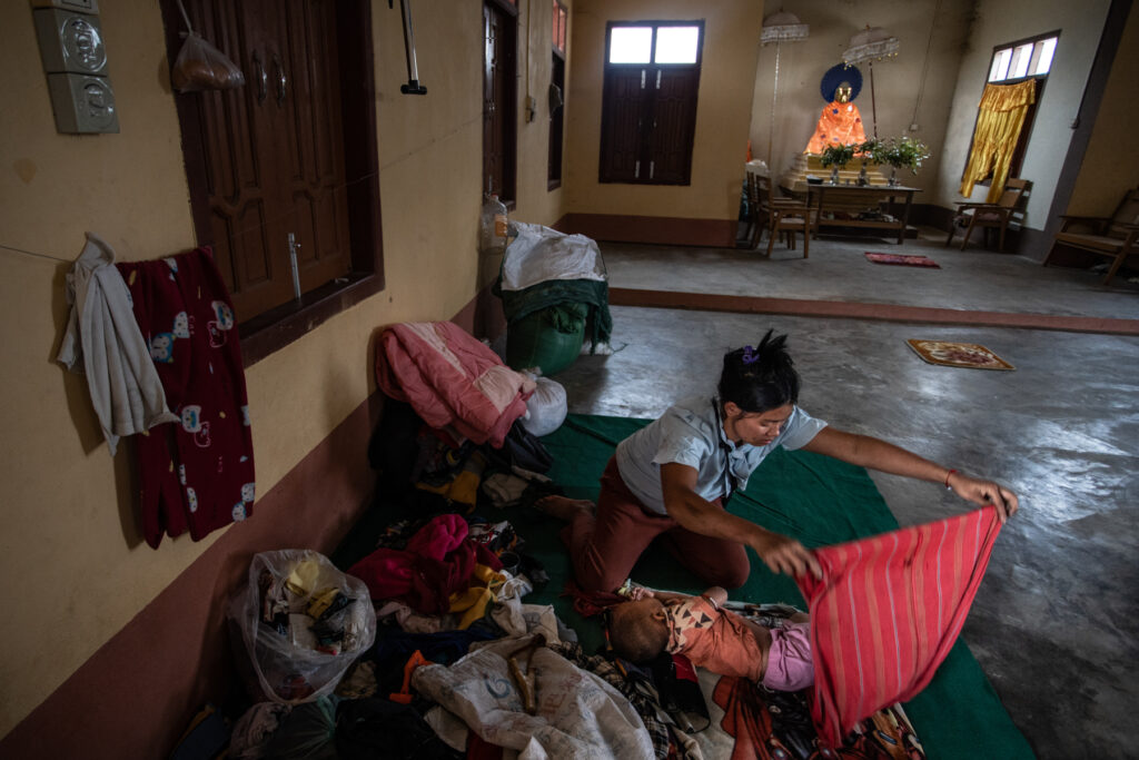 A displaced mother comforts her baby as they seek refuge inside a temple on 21 February 2025.