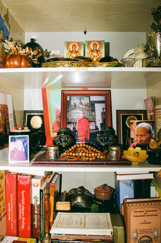 The Host, Aunty Sak showing her altar cabinet containing religious 
items, books, and documents.
