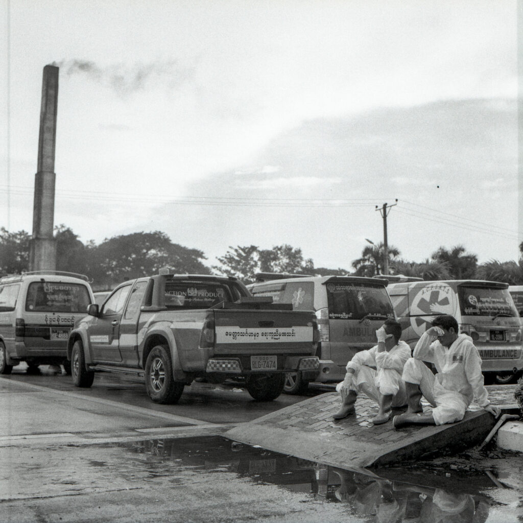 Volunteer funeral service workers rest as they wait to drop dead bodies from ambulance at Yayway cemetery on 22 July 2021.