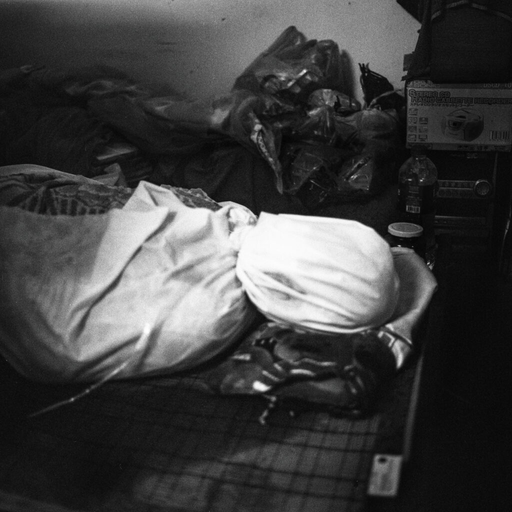 A body of a woman died from Covid-19 symptoms, is being wrapped with blanket is seen inside a residential apartment to be pick up by the free funeral service in Yangon on 20 July 2021.