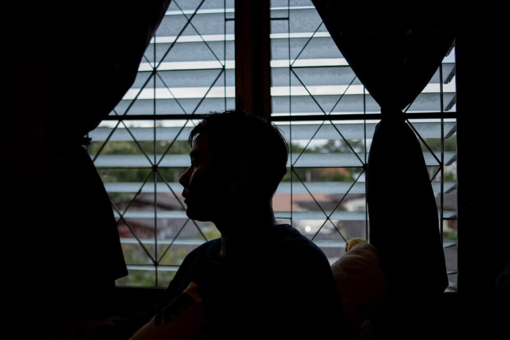 Dr. Amata, a Civil Disobedience Movement (CDM) doctor who fled to Thailand after Myanmar’s 2021 military coup, poses for a portrait at his apartment in Chiang Mai, Thailand. Unable to practice medicine in Thai hospitals due to legal restrictions, he continues to support fellow Myanmar exiles with his medical knowledge.