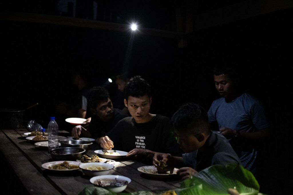 Members of the Bamar People’s Liberation Army (BPLA) share a evening meal at a jungle camp in Karen State, Myanmar, on February 18, 2024.