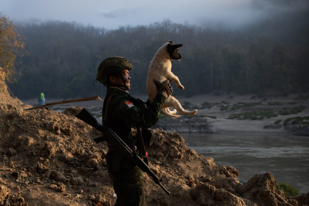 BPLA member plays with a puppy in Karen State, Myanmar, February 18, 2024. Founded in 2021 by urban activists following the military coup, the BPLA is one of the prominent armed groups representing the Bamar ethnic majority, fighting in alliance with ethnic minority groups to overthrow the military junta.