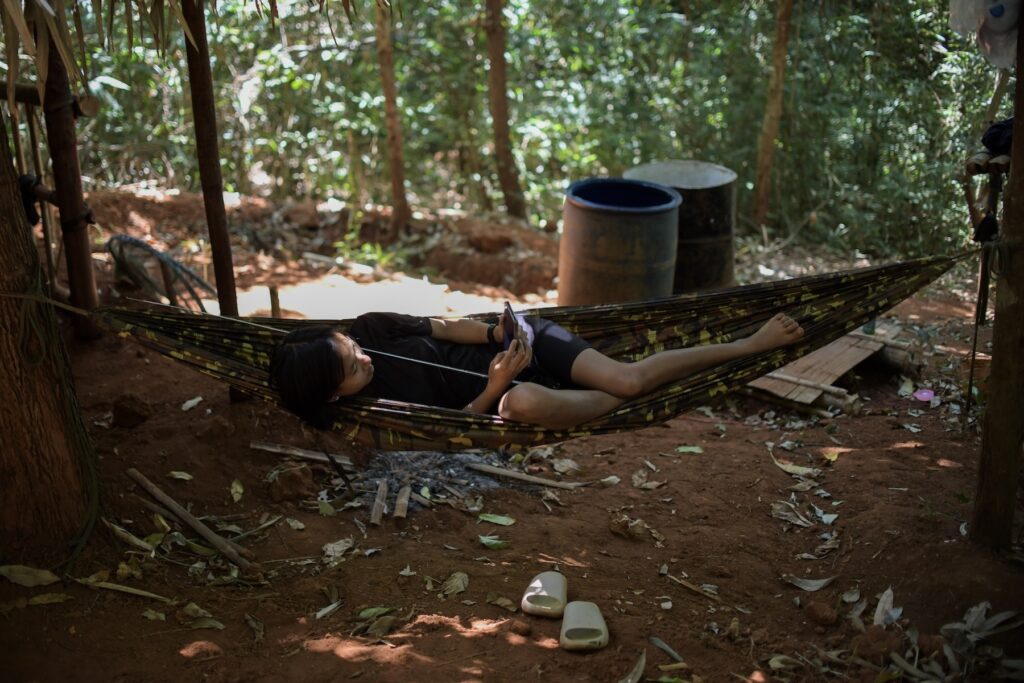 A woman soldier of BPLA rests in a hammock at a camp in Karen State, Myanmar, March 13, 2024.